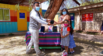 Imagen de un hombre haciendo entrega de un premio a una familia