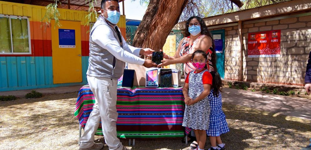 Imagen de un hombre haciendo entrega de un premio a una familia