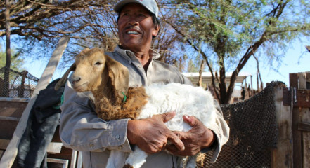 Se ve a un hombre sosteniendo a un chivo