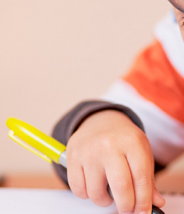 Se ve a un niño con un lápiz y un cuaderno