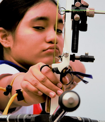 Se ve a una niña apuntando con un arco