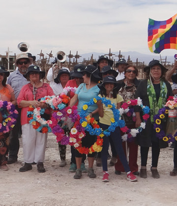 Se ve a un grupo de personas en el cementerio en el desierto